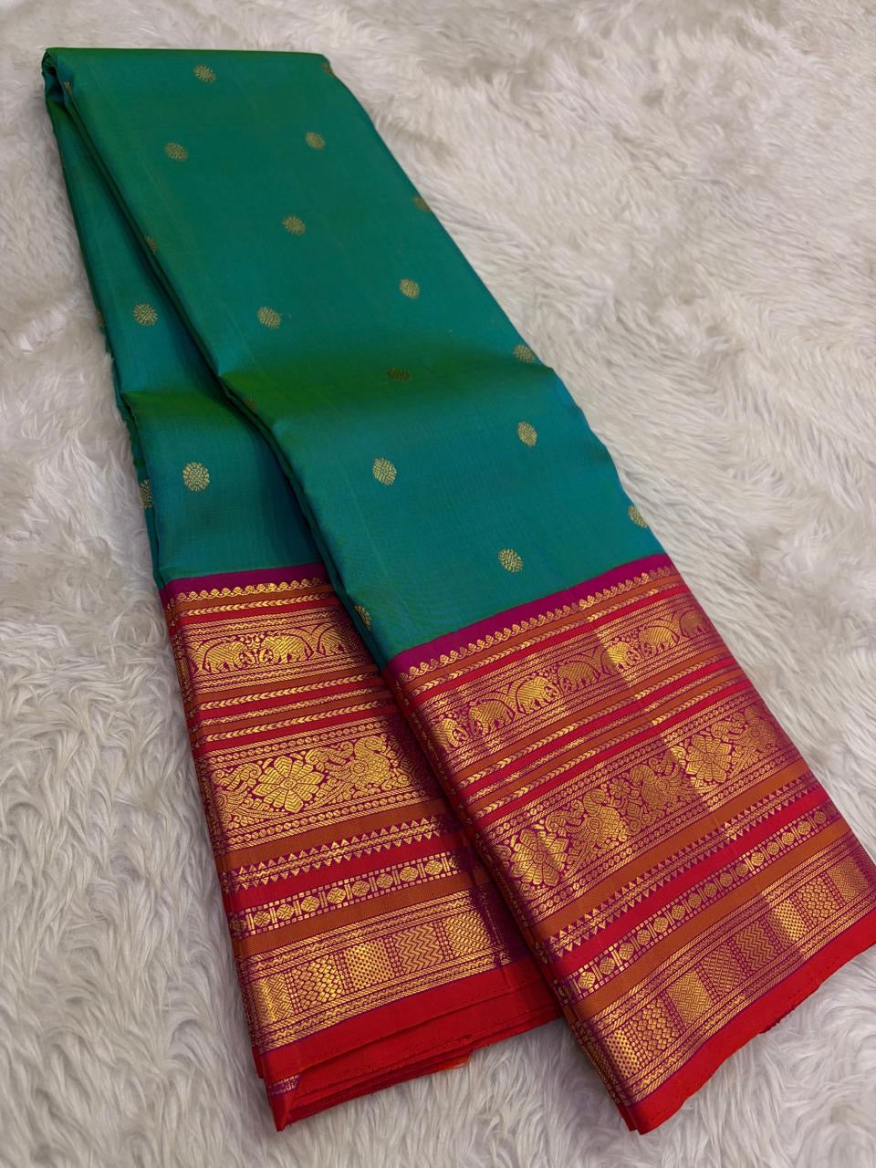 Kanchipattu silk saree in peacock teal with rani pink border Korvai Varisaipet weave traditional zari detail