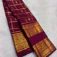 Deep lac-maroon handwoven Kanchipuram silk showing fine gold Kattam structure and traditional body buttas.