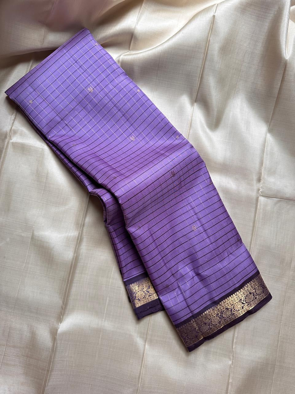 Lavender checked Kanchipuram silk saree drape showing fine kattam lines and zari woven border