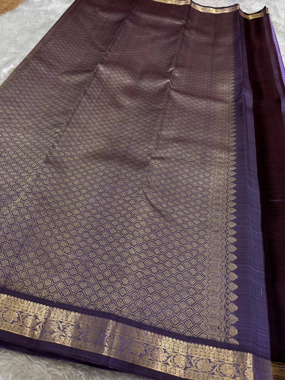 Folded lavender Kanjivaram pure silk saree showing Zari Kattam grid body and deep purple border