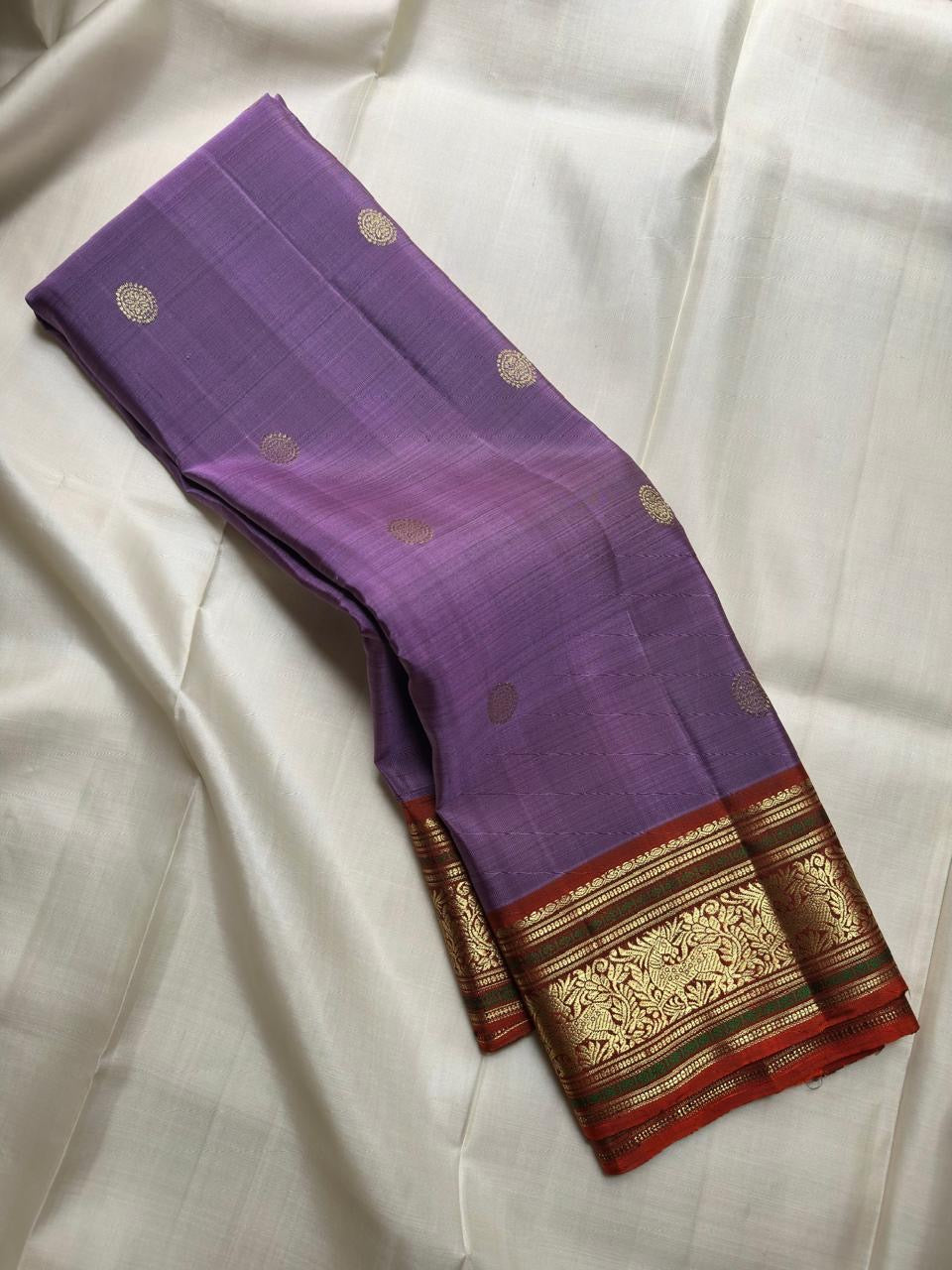 Lavender Kathiripoo Pure Silk Kanchipuram Butta saree with gold buttas and warm Rust-Arakku zari border.
