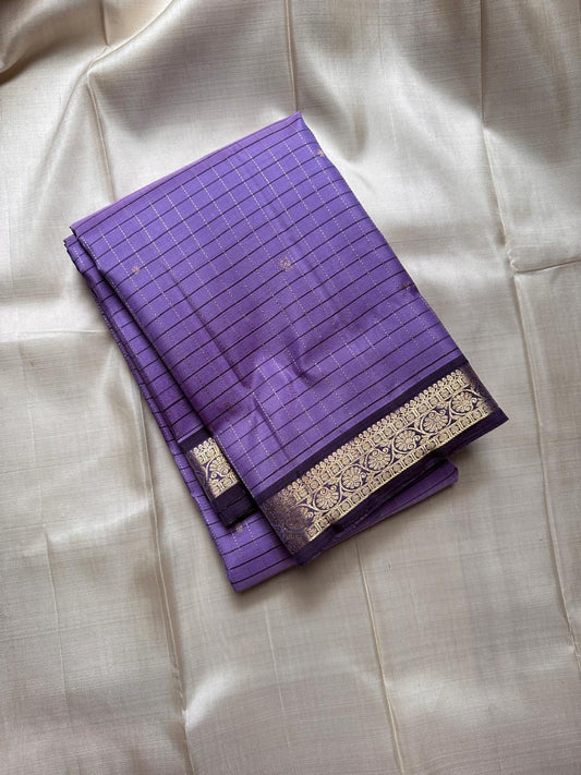 Folded lavender muthu kattam Kanchipuram silk saree with zari woven border on ivory fabric