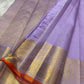 Close-up of lavender pure Kanchipuram silk saree showing gold zari border panels and orange selvedge.