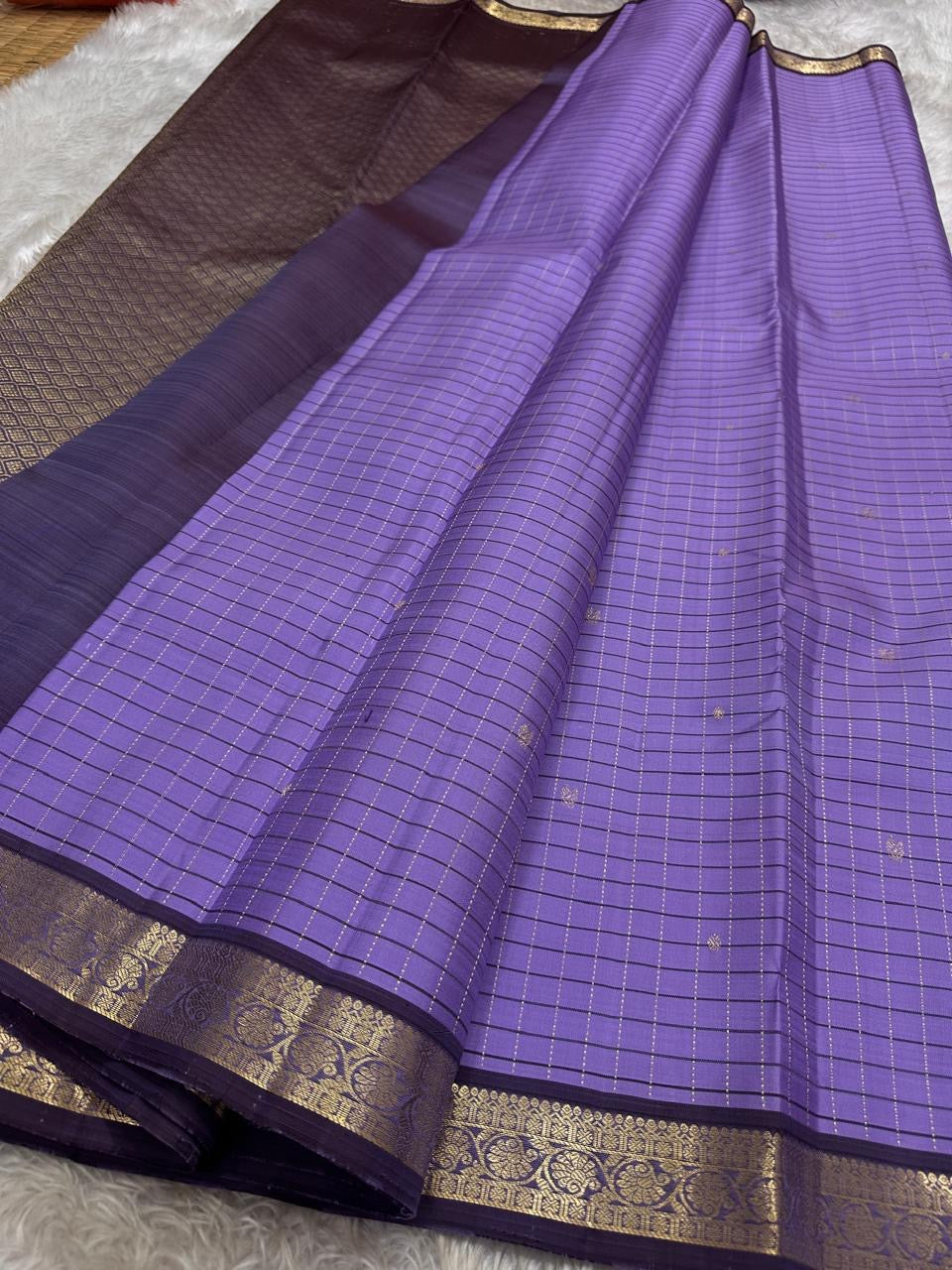 Lavender muthu kattam body with contrasting deep plum pallu and zari woven border, spread out