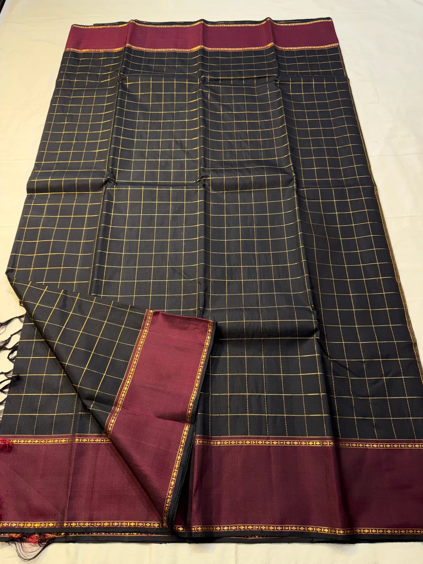 Full spread view of black checked Pure Kanchipuram Silk Saree with maroon border and slim zari edge along the width