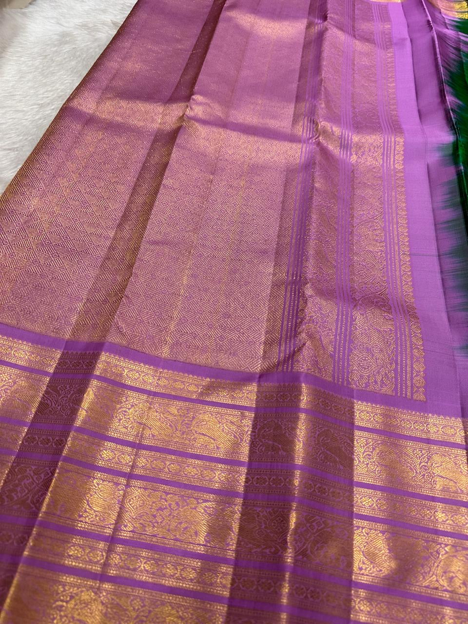 Leaf-green accent detail on an orchid-lilac handwoven pure silk Kanchipuram Varisaipet saree