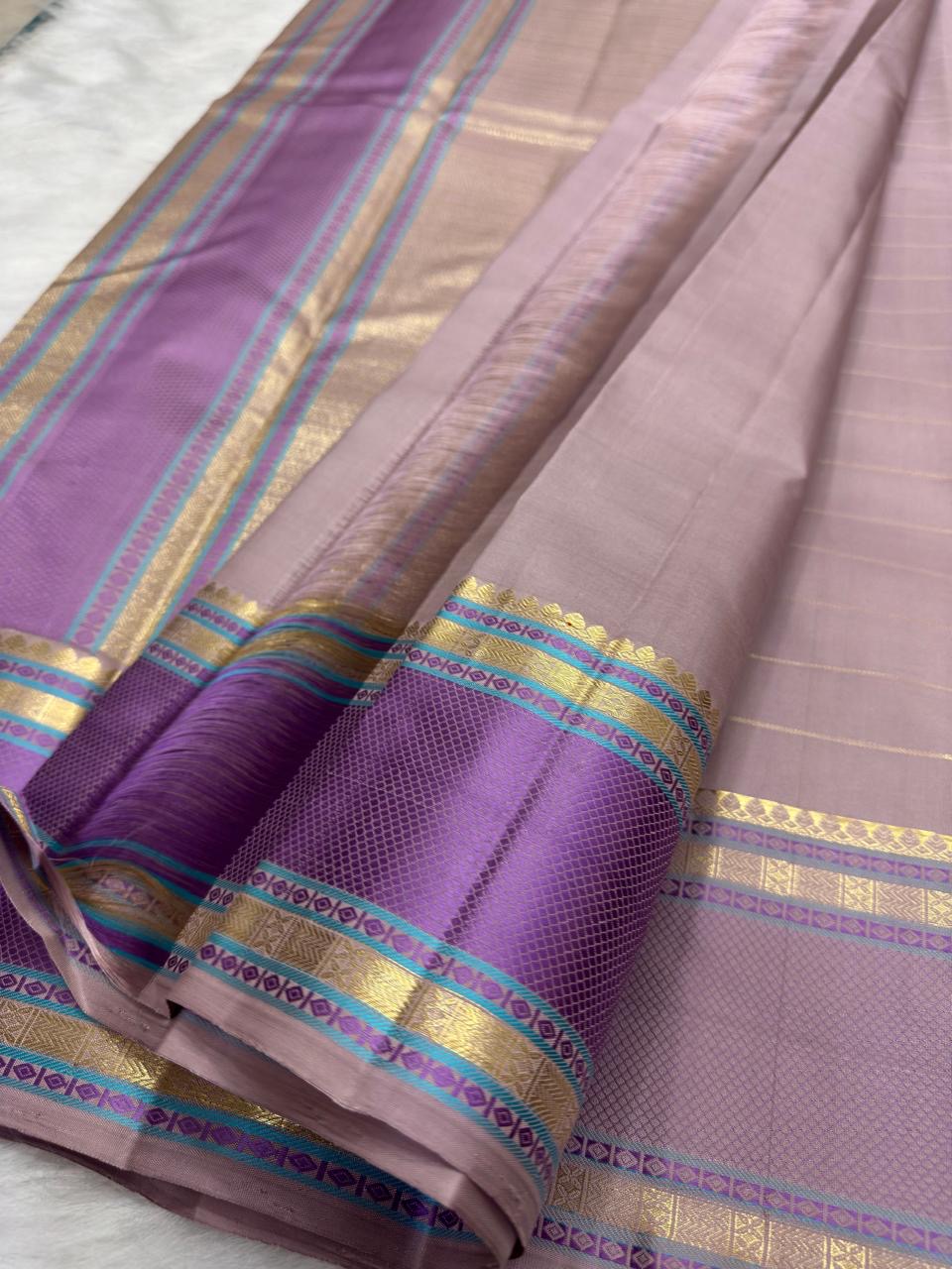 Turquoise silk-thread accents on lavender border, dusty-lilac Kanjivaram saree