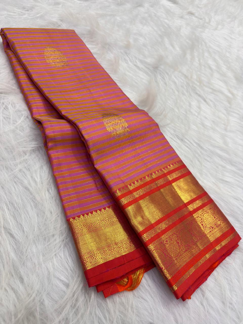 Handwoven Chen buttas spaced across the striped silk body of the peach purple gold Vairaoosi saree.