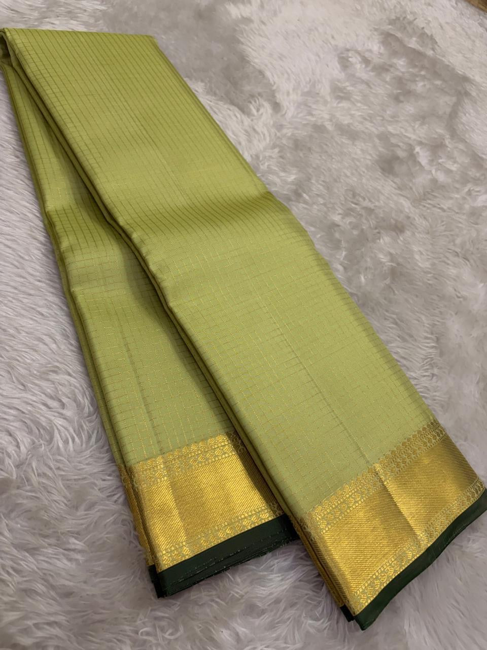 Thick antique gold zari woven border with floral and geometric motifs on pistachio Kanchipuram saree