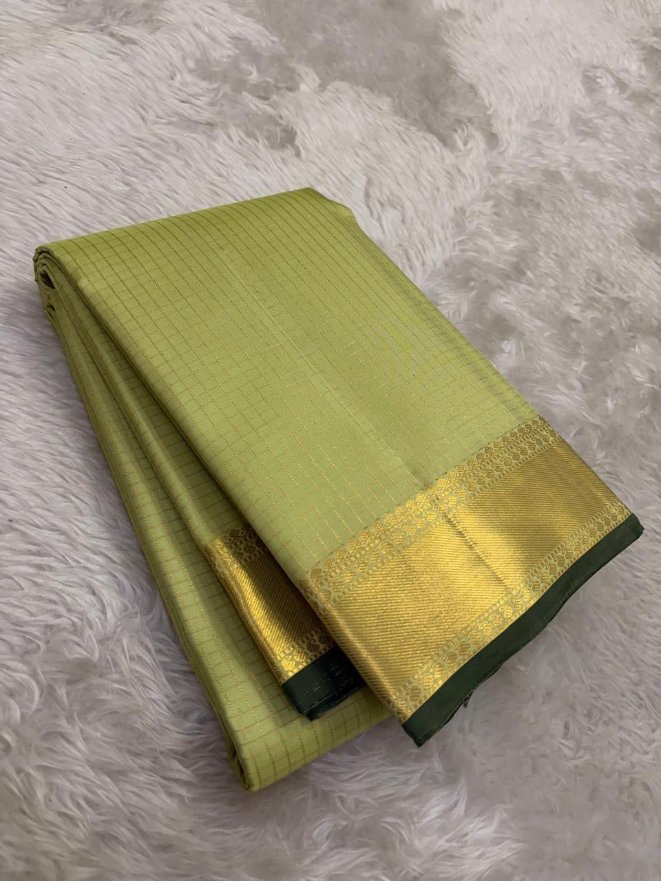 Diagonal zari woven pallu in antique gold cascading across pistachio silk ground
