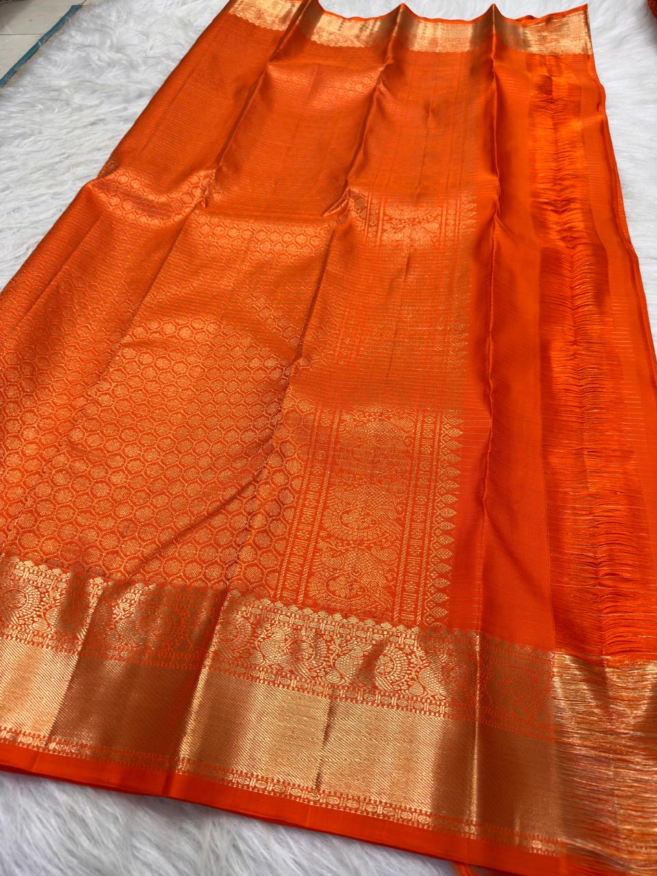 Luminous antique-gold zari border on Radiant Burnt Orange Kanchipuram silk saree.