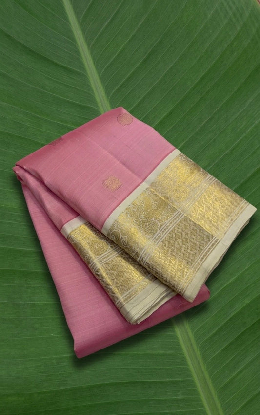 Luscious petal pink Kanchipuram silk saree with ivory korvai border and mayil chakram zari butta folded view