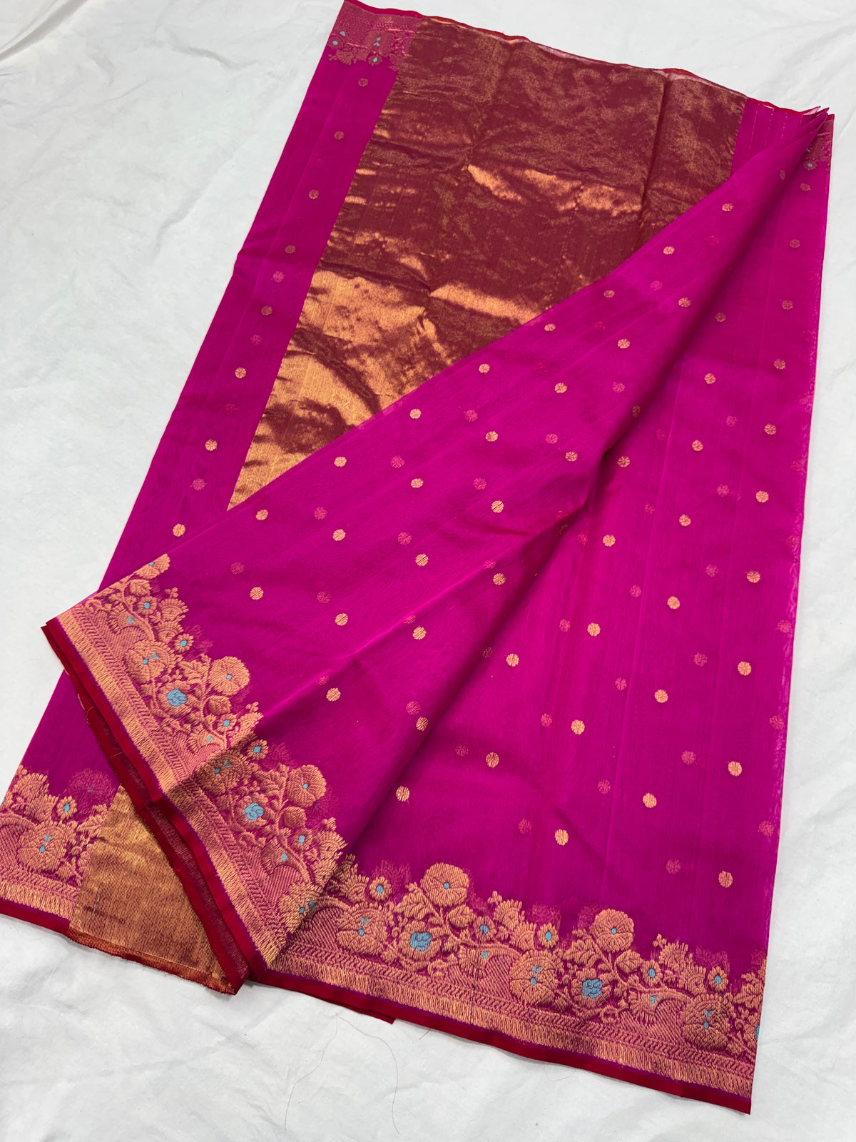 Purplish pink Chanderi saree opened to show the full gold-toned pallu and floral border with turquoise accents