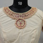 Close-up of durable kemp stones and hand embroidery on cream silk blouse