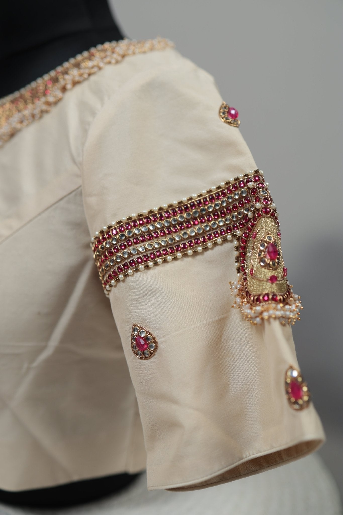 Beige sleeve with intricate jewelry design on a plain background
