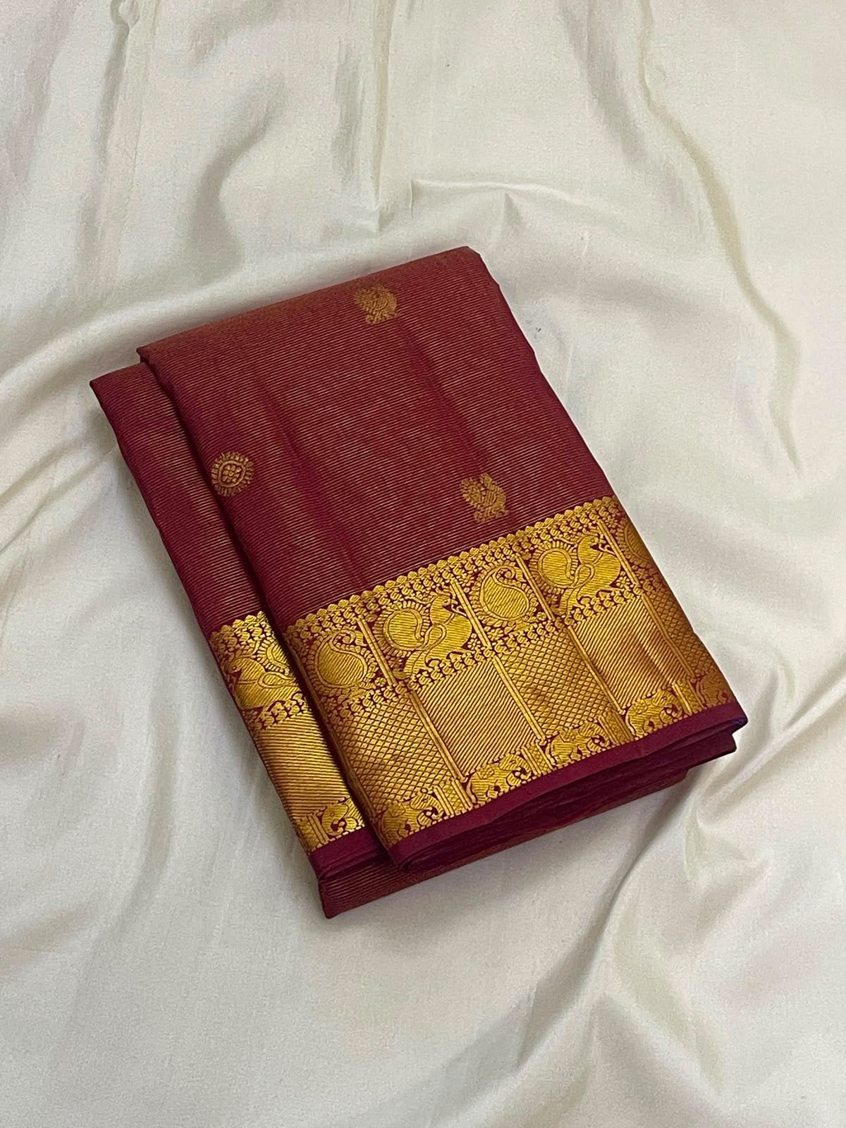 Maanga paisley motif on the gold zari border of the Arakku maroon Kanchipuram Vairaoosi saree