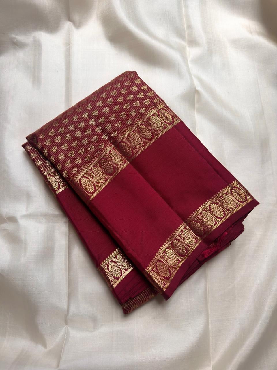 Broad plain Arakku pettu framed by compartmented floral-paisley zari work and fine geometric reku detailing.