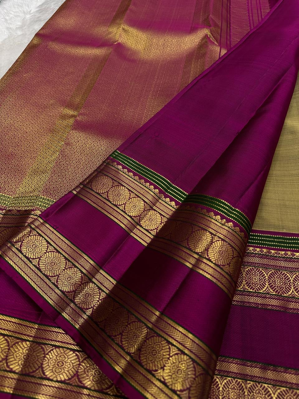 Magenta border detail on a champagne gold Kanchipuram saree.