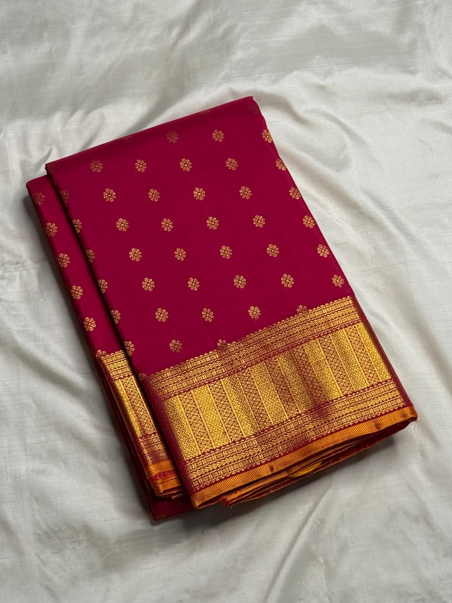 Magenta silk surface with repeating gold zari kamalam lotus butta detail