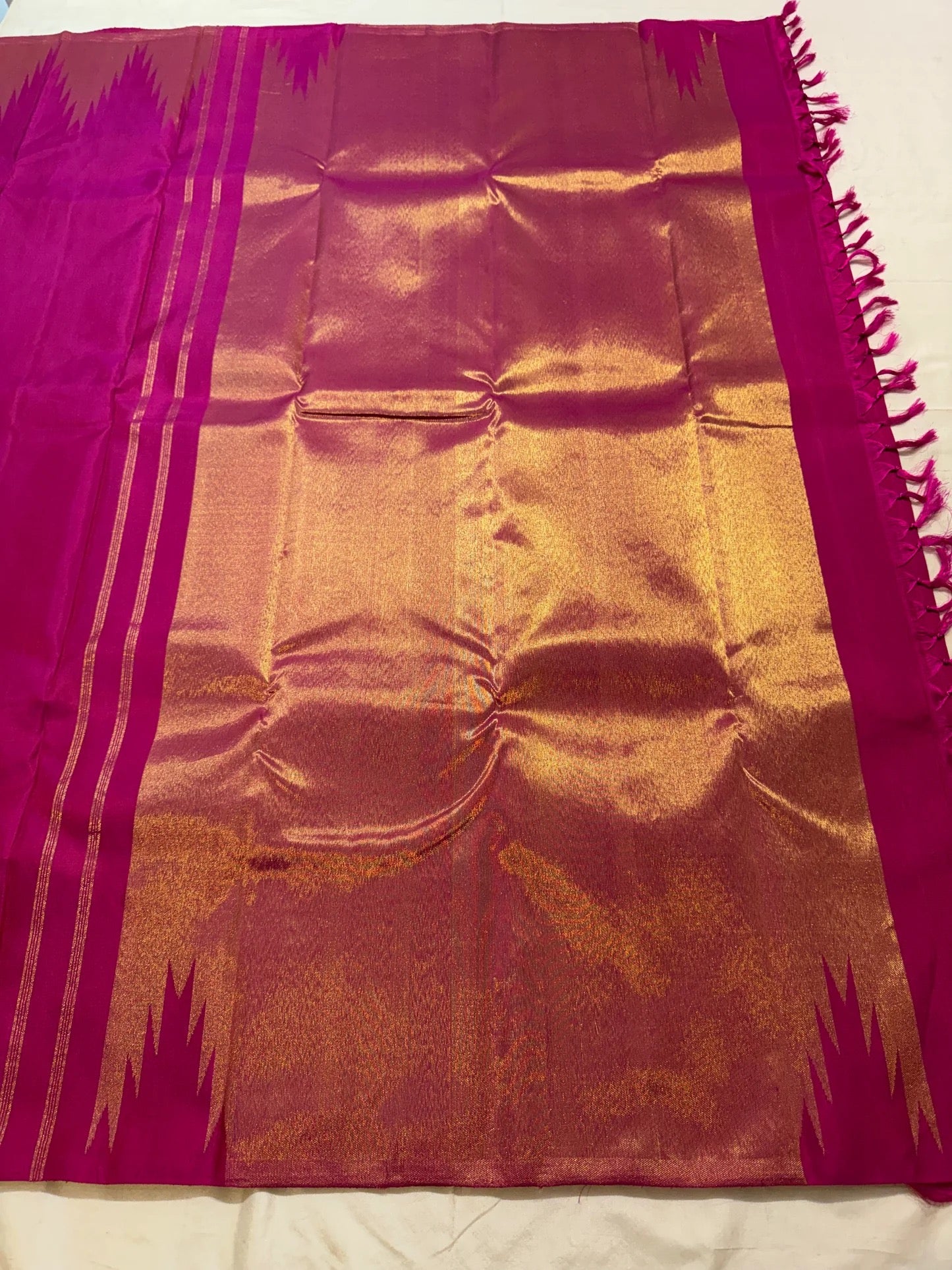 Gold Ettukol zari flame-edged border close-up on magenta Kanjivaram saree
