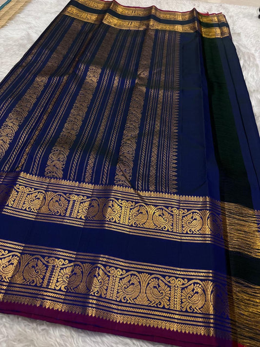 Navy blue Kanjipuram silk saree body close-up showing Mayil peacock and Pavun coin antique gold zari butta motifs