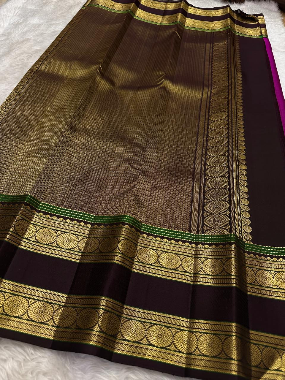 Border detail on the magenta rettapet saree with green highlight lines.