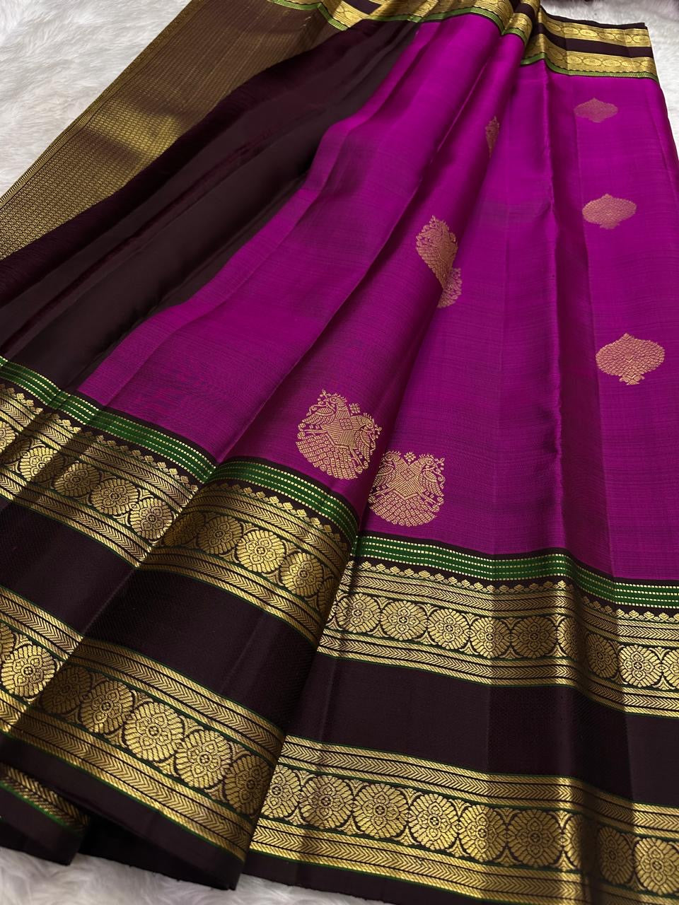 Rose-gold tissue pallu on the magenta pink Kanjivaram rettapet saree.