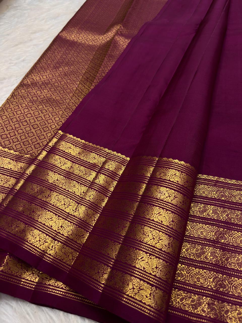 Gold-rich pallu on the deep brown Kanchipuram butta saree.