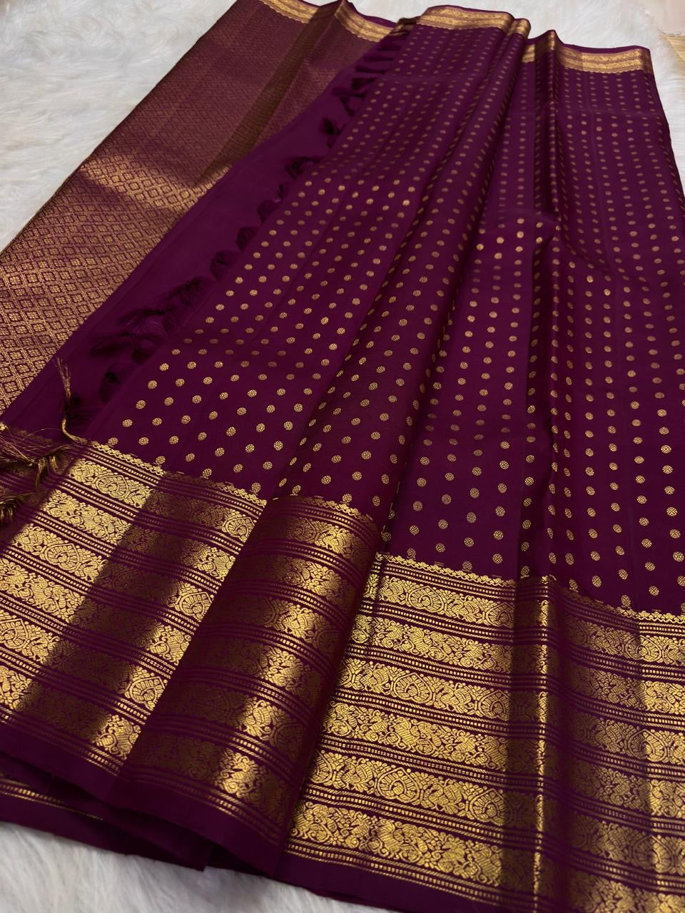Displayed deep brown handwoven Kanchipuram butta saree.