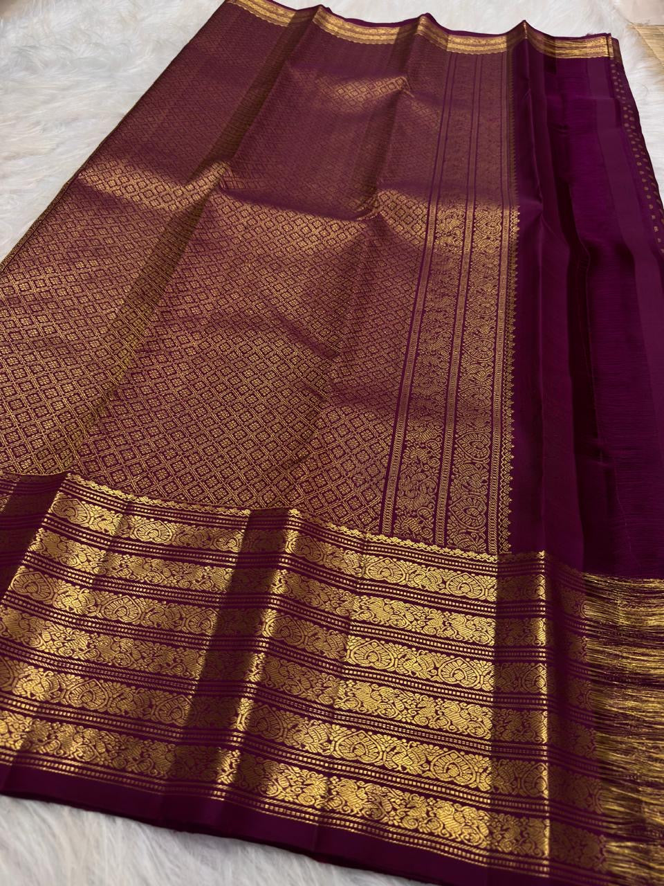 Varisaipet border detail on the deep brown Kanchipuram saree.