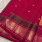 Vadamalli magenta pallu with circular gold buttas and a deep olive-green zari border
