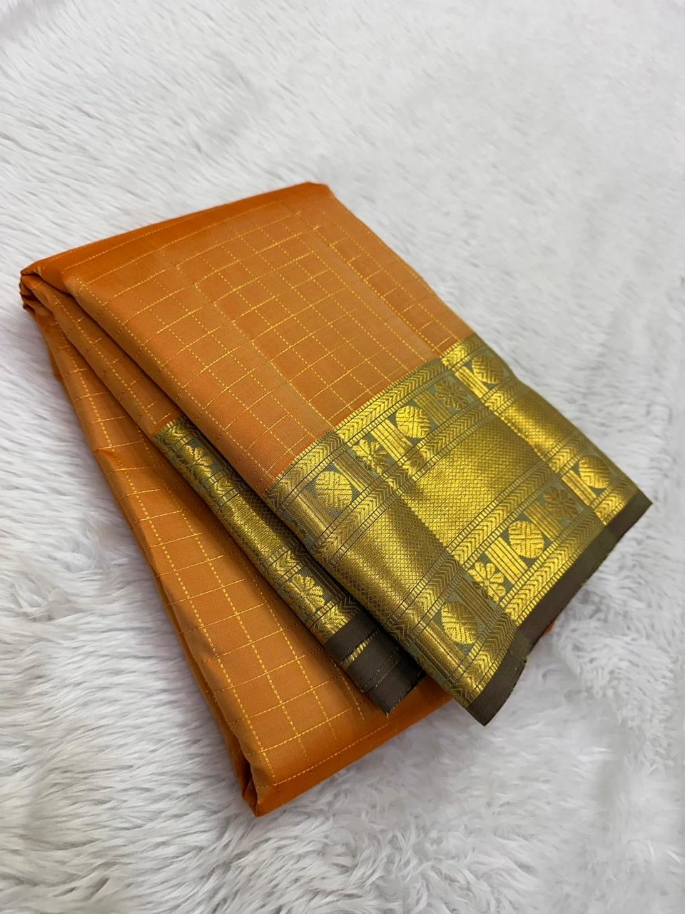 Manthulir-brown border detail on mango-yellow Kanjeevaram saree