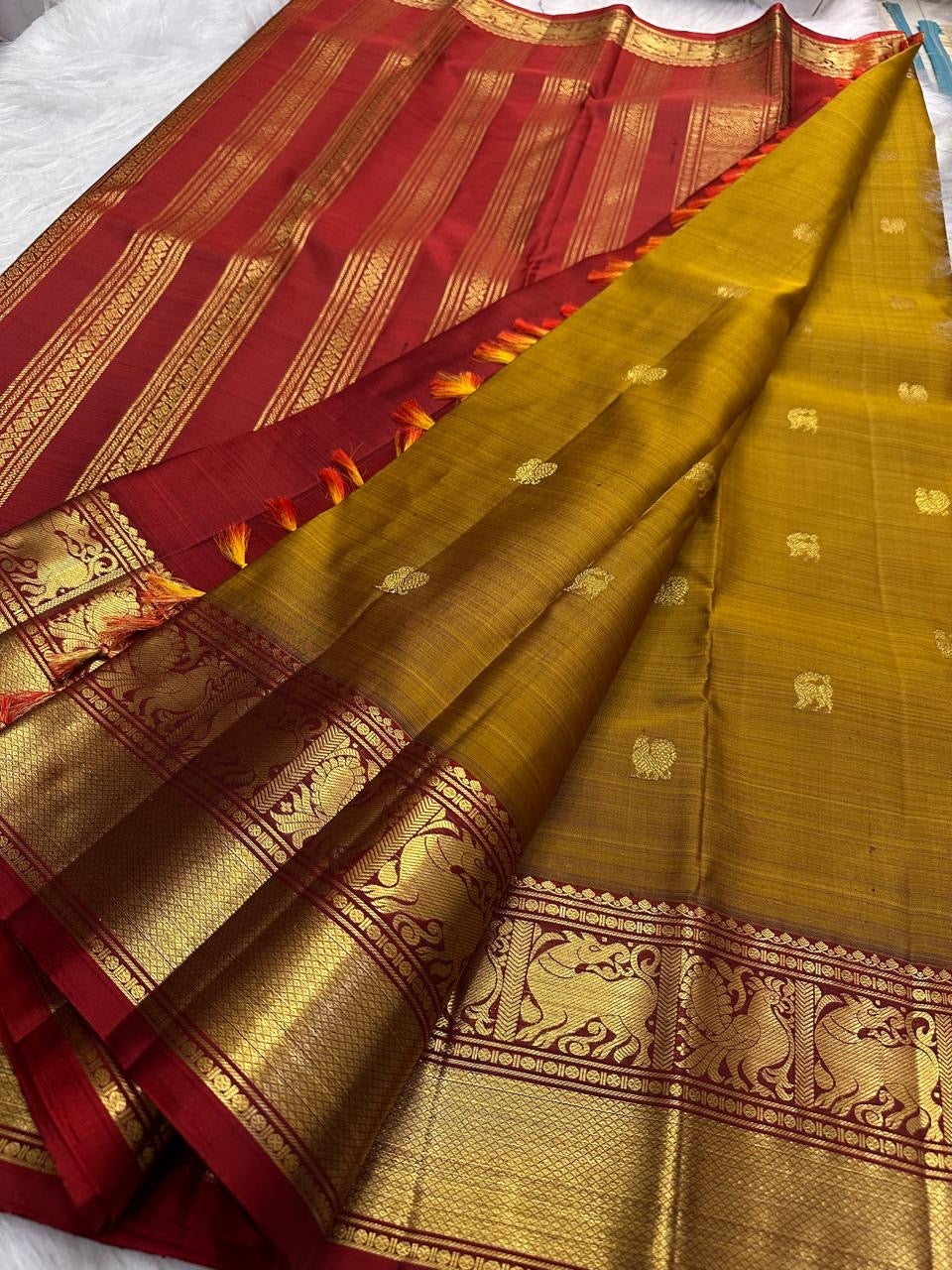 Deep Arakku Kanchipuram pallu with long vertical zari seer lines and repeated ornamental zari registers.