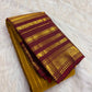 Folded mustard-yellow Kancheepuram silk saree with a deep Arakku Varisaipet border and gold zari elephant motifs.