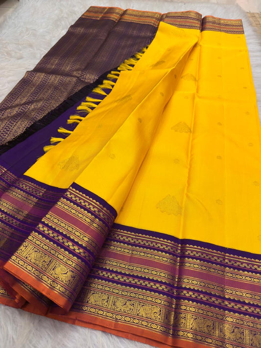 Handwoven radiant turmeric-flower manjal yellow contrasted with deep violet-purple Varisaipet pure silk Kanchipuram saree with rich zari border