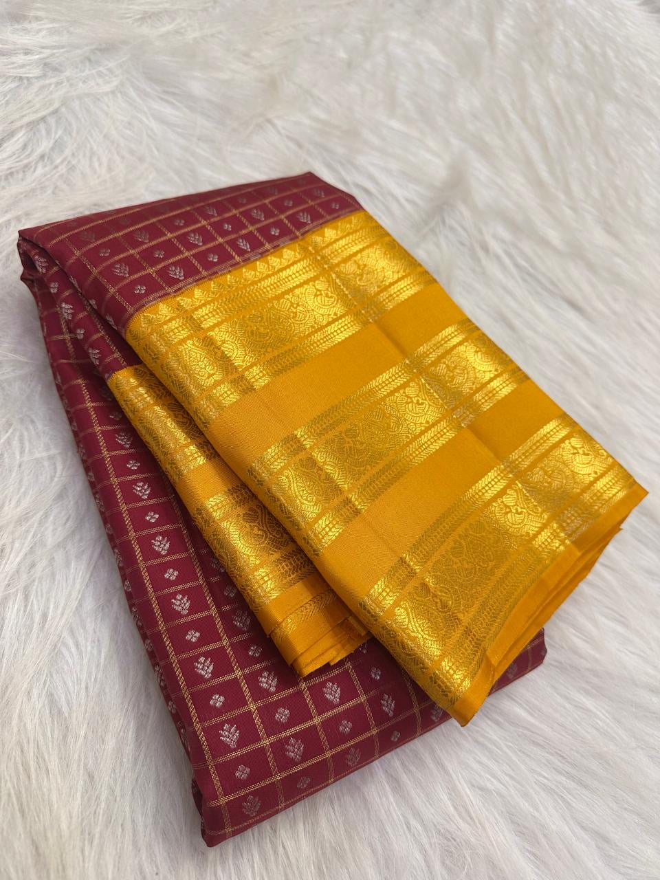 Varisaipet border detail on the plum purple and yellow Kanchipuram saree.
