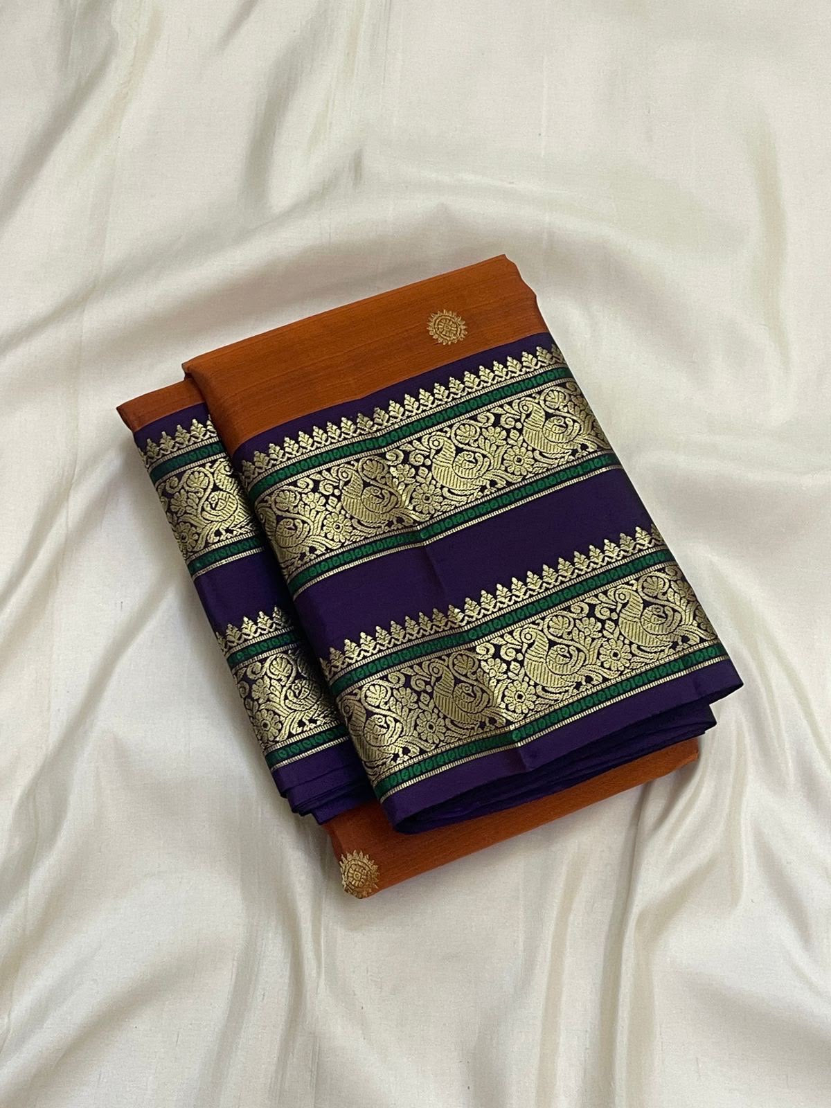 Saturated purple Kanchipuram pallu with circular zari buttas and an elaborate vertical zari register.