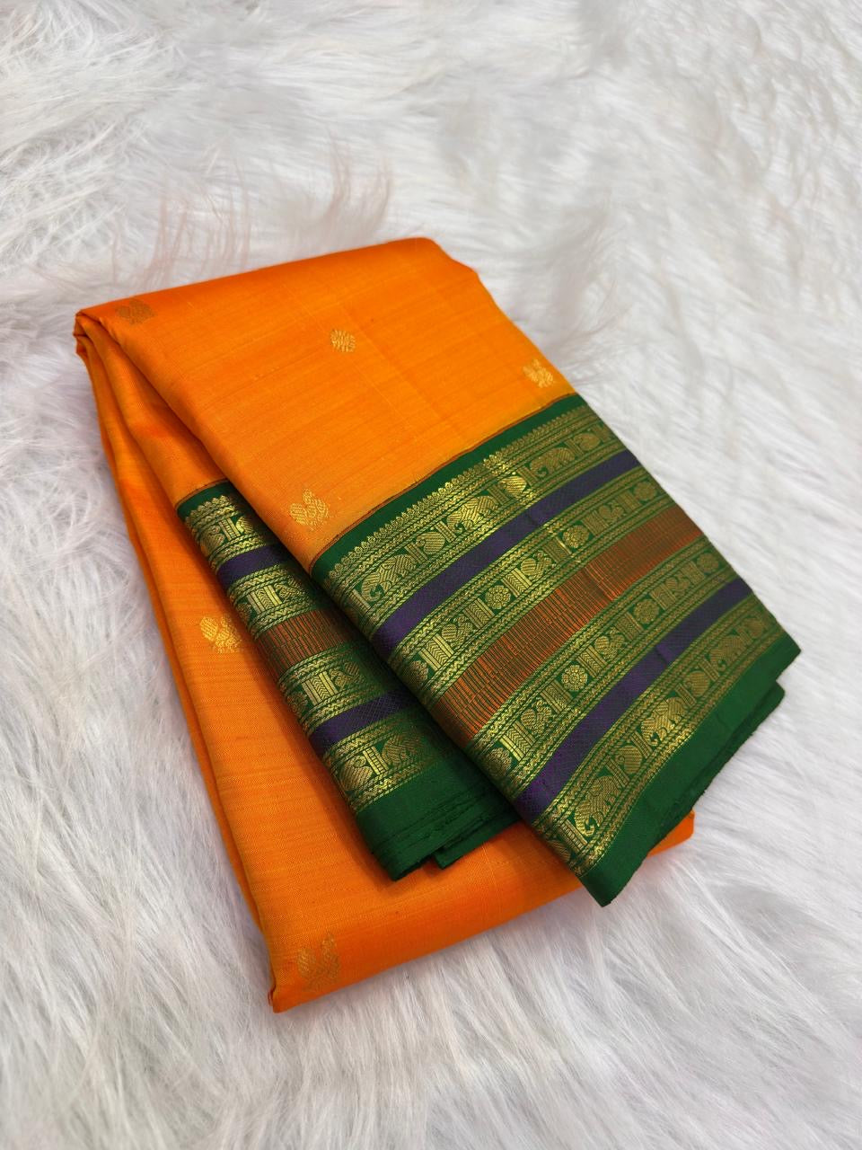 Marigold orange Kanjivaram silk saree with Maragatham green layered border.