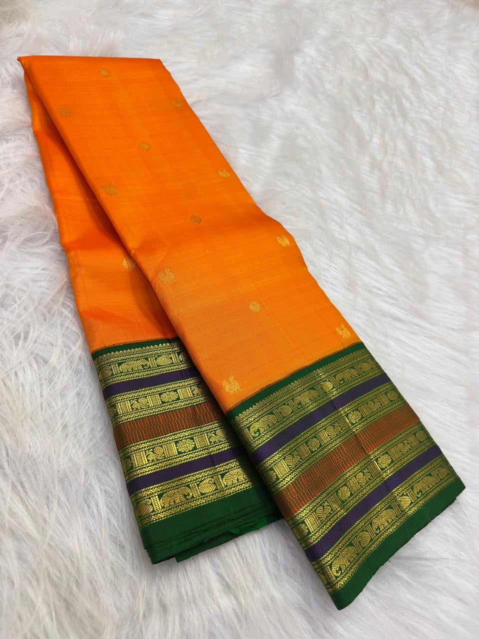 Marigold orange handwoven Kanchipuram varisaipet silk saree with Maragatham green border.