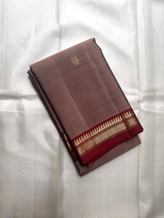 Pure Kanchipuram silk saree spread open showing maroon pallu with vertical zari panels and contrast beige body