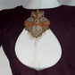 Brown blouse with a decorative brooch on a mannequin against a white background
