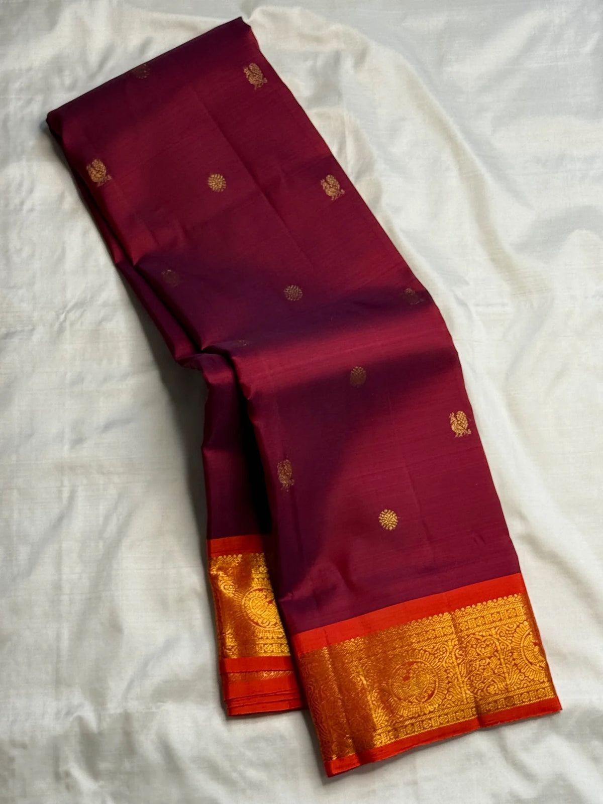 Deep Ennai Arakku Pure Silk Kanchipuram Butta saree with Orange border.
