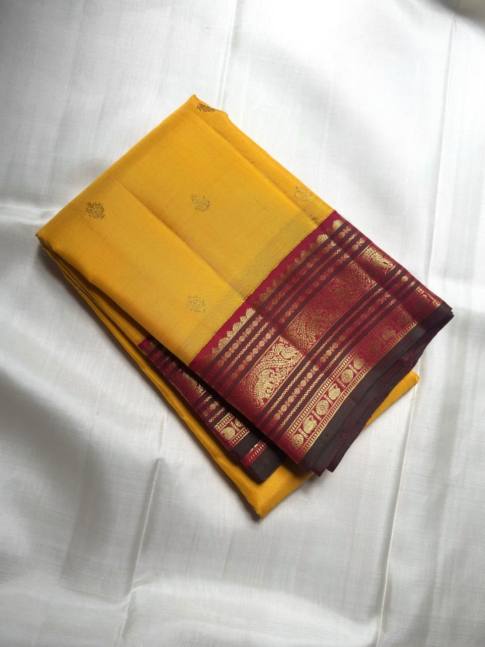 Deep Maroon Kanchipuram Korvai pallu showing dense gold zari geometry and richly woven ornamental side panels.