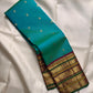 Deep maroon Kanchipuram Varisaipet pallu densely woven with gold zari ornamental columns and rich green accents.