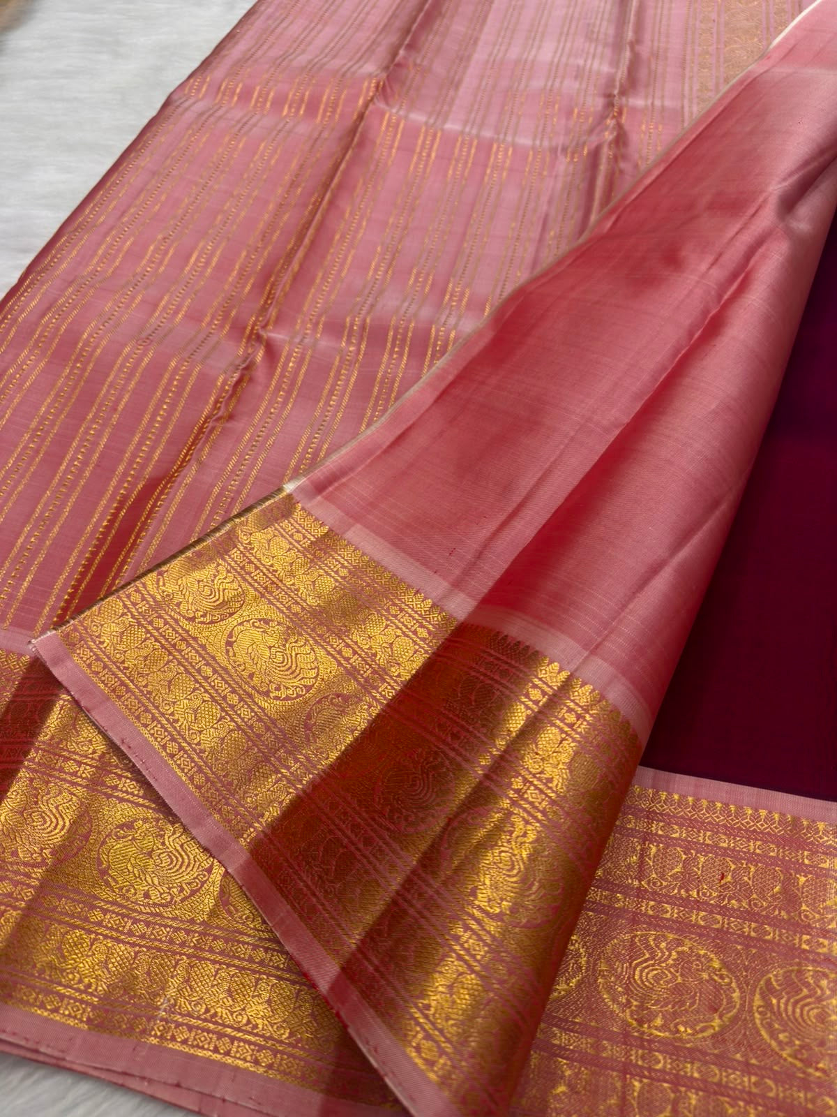 Deep raspberry maroon KanchiPattu saree with peacock gold zari border