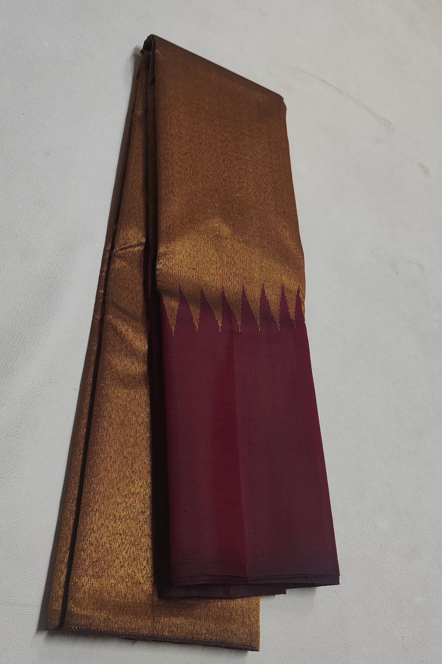 Close-up of ettukol gold zari border on maroon handwoven Kanchipuram saree — Idam Living