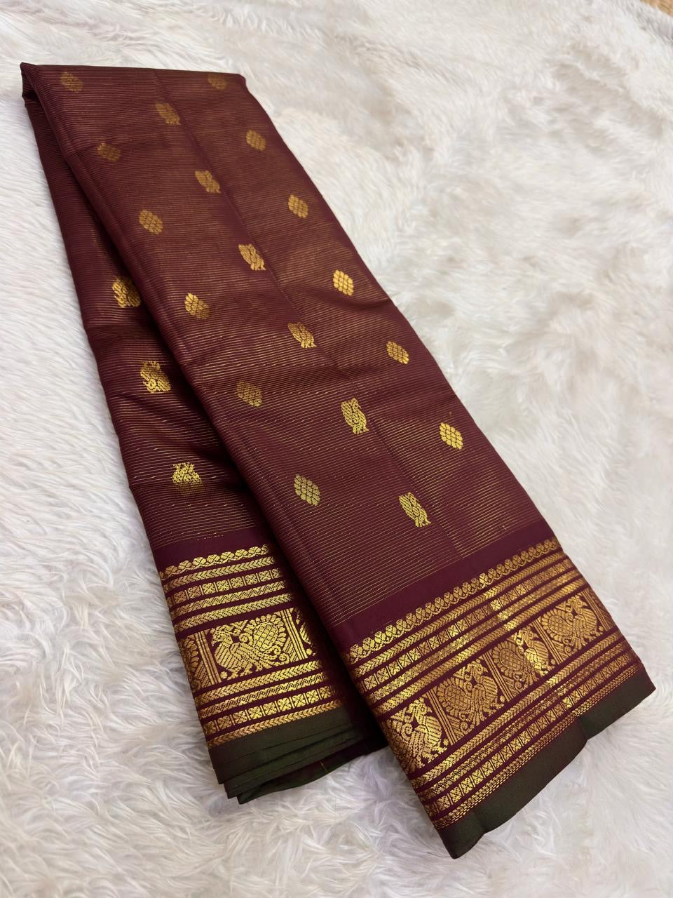 Close-up of maroon Kanjivaram silk saree body showing gold zari vairaoosi weave and mayil peacock butta — Idam Living