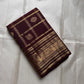 Deep cinnamon brown lightweight Kanjeevaram silk saree with peacock motif zari border
