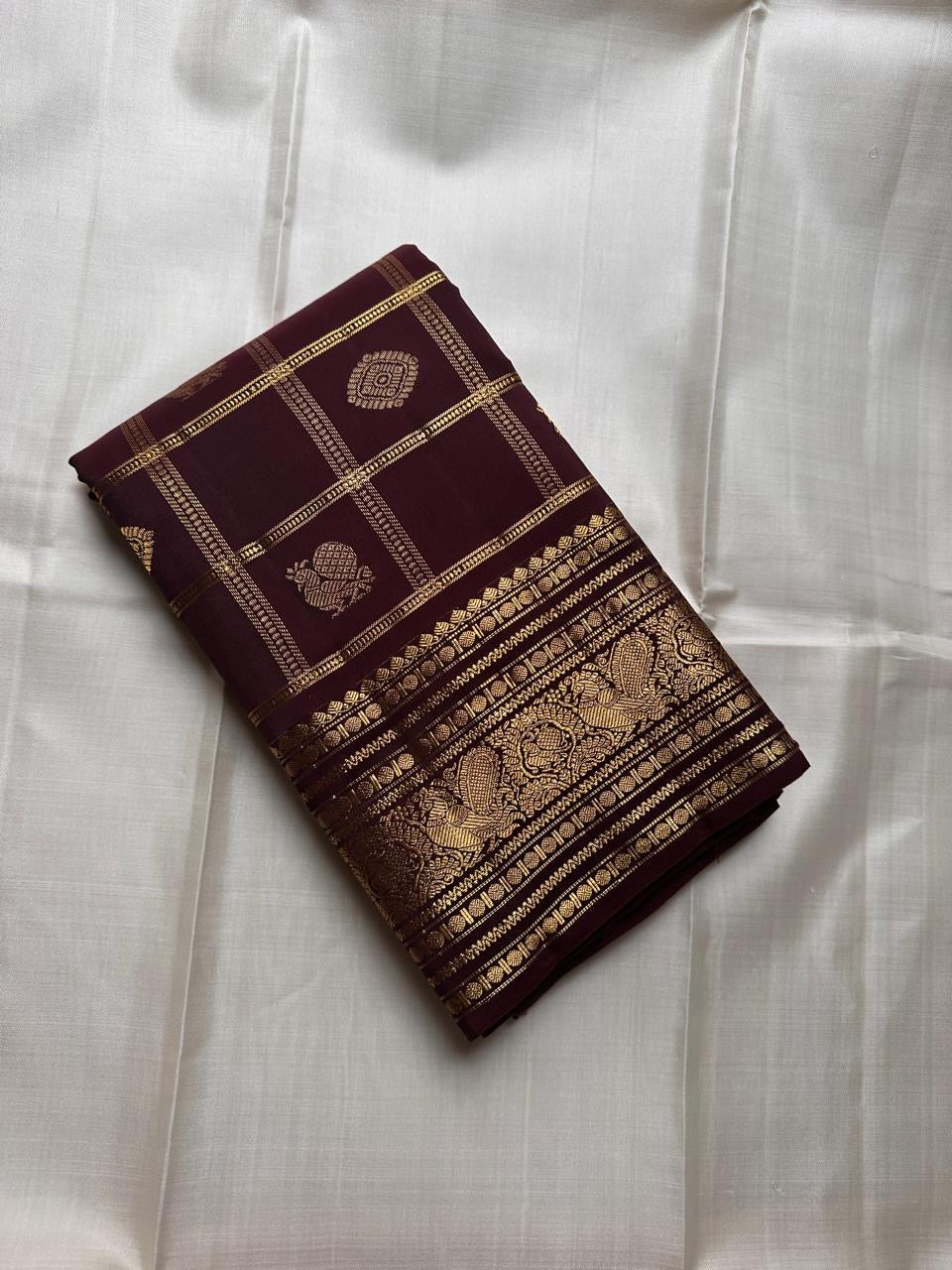 Deep cinnamon brown lightweight Kanjeevaram silk saree with peacock motif zari border