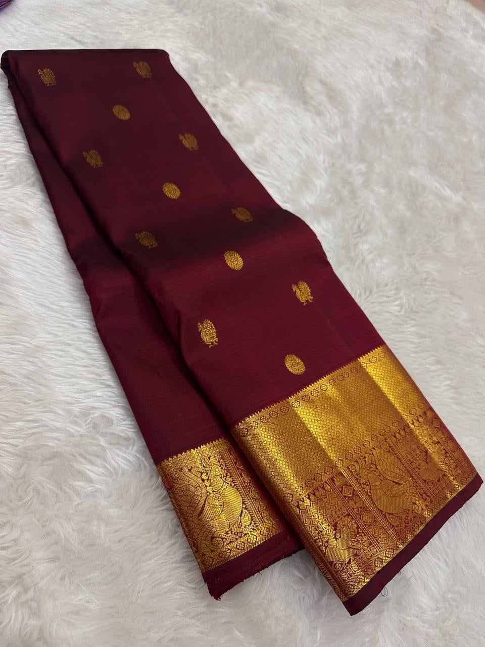 Gold zari mayil chakram peacock-wheel butta detail on maroon body